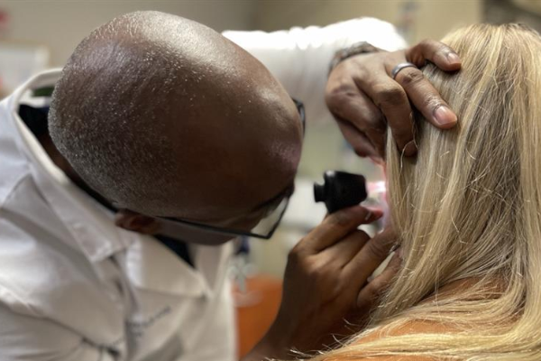 Audiologist Harlan Carroll giving a hearing exam